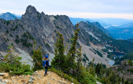 Woman climber gazing at mountains and lake, symbolizing the journey to financial freedom with Northern Pacific Asset Management in Houston, TX.