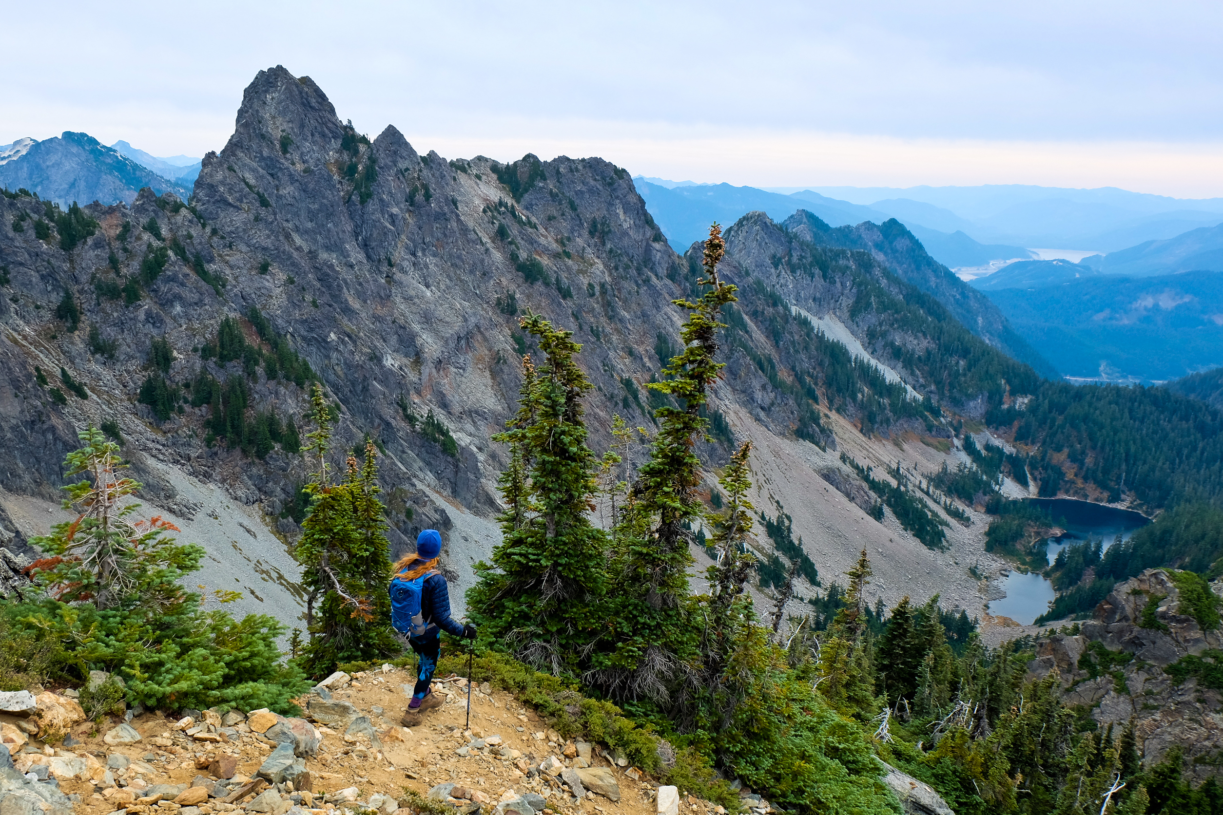 Woman climber gazing at mountains and lake, symbolizing the journey to financial freedom with Northern Pacific Asset Management in Houston, TX.