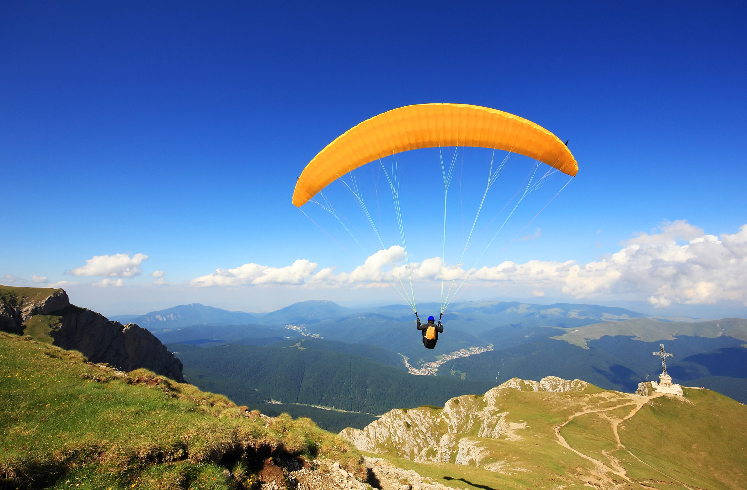 Paraglider preparing to launch from a mountain, symbolizing business exit planning with Northern Pacific Asset Management in Houston, TX