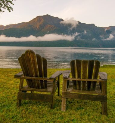 Parallel chairs overlooking a peaceful landscape in the Pacific Northwest, representing the strategic alignment and balance of parallel SLATs in estate tax planning. This visual ties directly to the concept of parallel SLATs by illustrating how two entities (the chairs, or the trusts) can remain distinct yet aligned, offering a clear metaphor for the estate planning strategy.