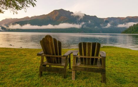 Parallel chairs overlooking a peaceful landscape in the Pacific Northwest, representing the strategic alignment and balance of parallel SLATs in estate tax planning. This visual ties directly to the concept of parallel SLATs by illustrating how two entities (the chairs, or the trusts) can remain distinct yet aligned, offering a clear metaphor for the estate planning strategy.
